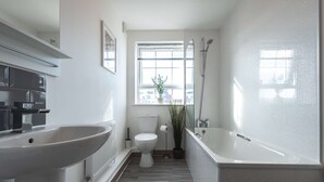Une salle de bain moderne avec un grand lavabo, des toilettes et une baignoire.