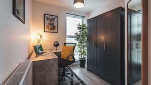 A modern office space with a desk, chair, and a large wardrobe.
