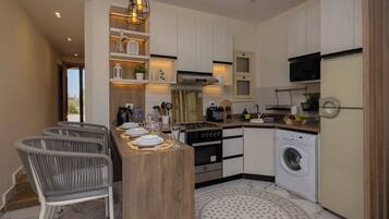 A modern kitchen with a central island, built-in appliances, and a dining area with a bar stool.