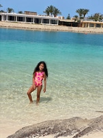 En la playa, arena blanca, sillas reclinables de playa, sombrillas