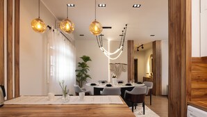 A modern dining area with a wooden table, grey chairs, and pendant lighting. - Marina Resort By Seven Seasons (Al-Hammam)