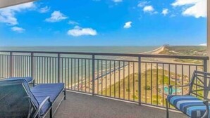 Ein Balkon mit Blick auf Strand und Meer.