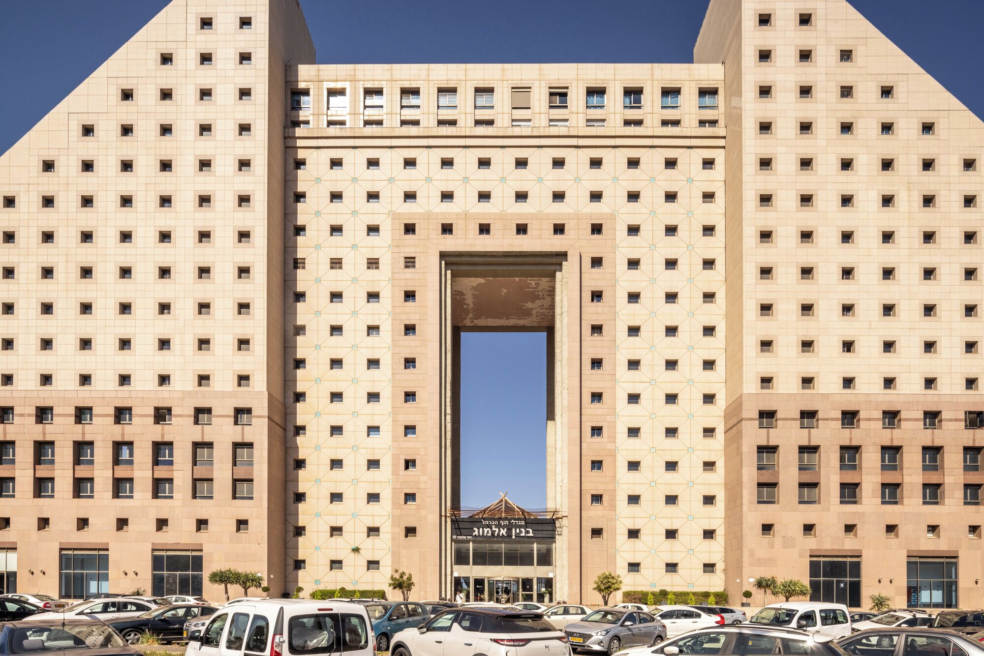 Ein großes Gebäude mit einem zentralen Eingang und mehreren Fenstern.