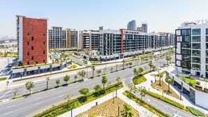 Una zona urbana moderna con edificios de varios pisos, amplias avenidas y áreas ajardinadas con palmeras.