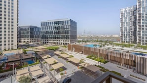 A modern residential complex with high-rise buildings, a swimming pool, and a landscaped courtyard. - Silkhaus Socio Towers Dubai Hills (Dubai)