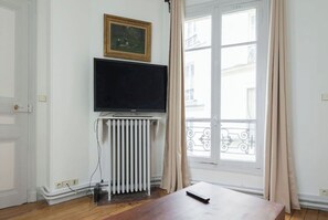 Enjoy a serene view from the large window, with a flat-screen TV and a convenient table nearby.
