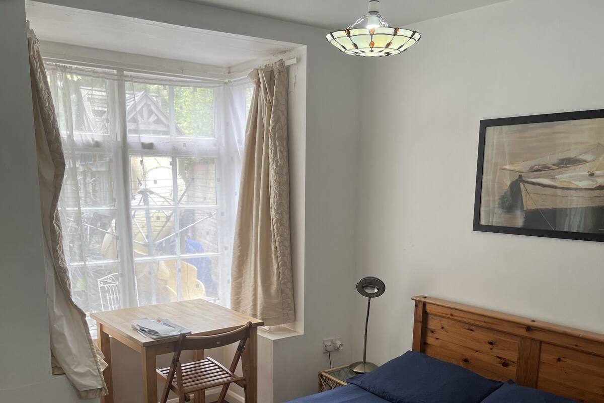 A bedroom with a wooden bed, a desk, and a chair.