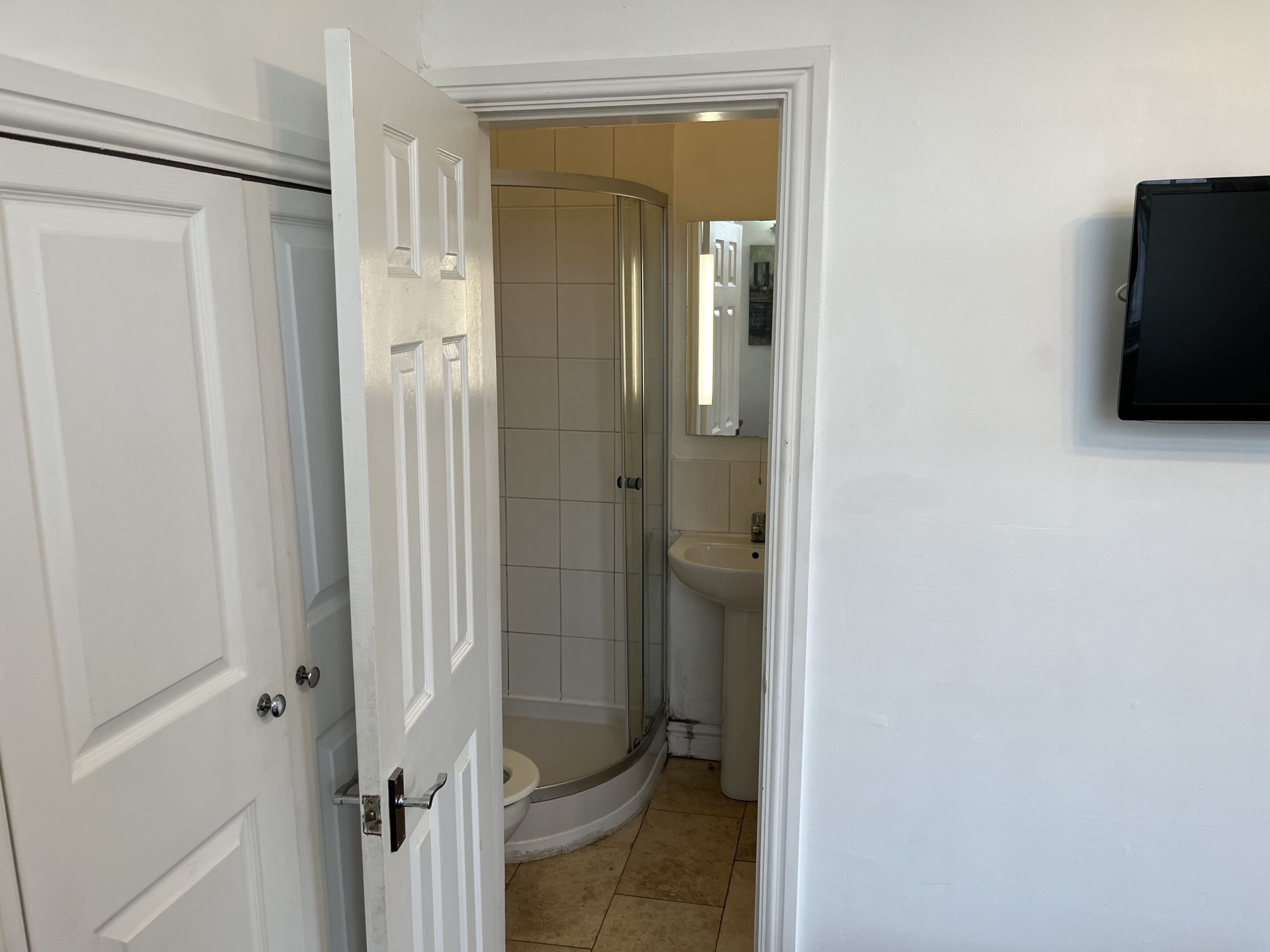 Een badkamer met een douche, toilet en wastafel.