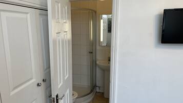 Un baño con ducha, inodoro y lavabo.