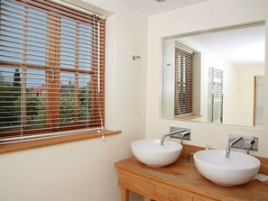A bathroom with two white vessel sinks, a large mirror, and wooden cabinetry. - Beverley Budget Inn (Beverley)