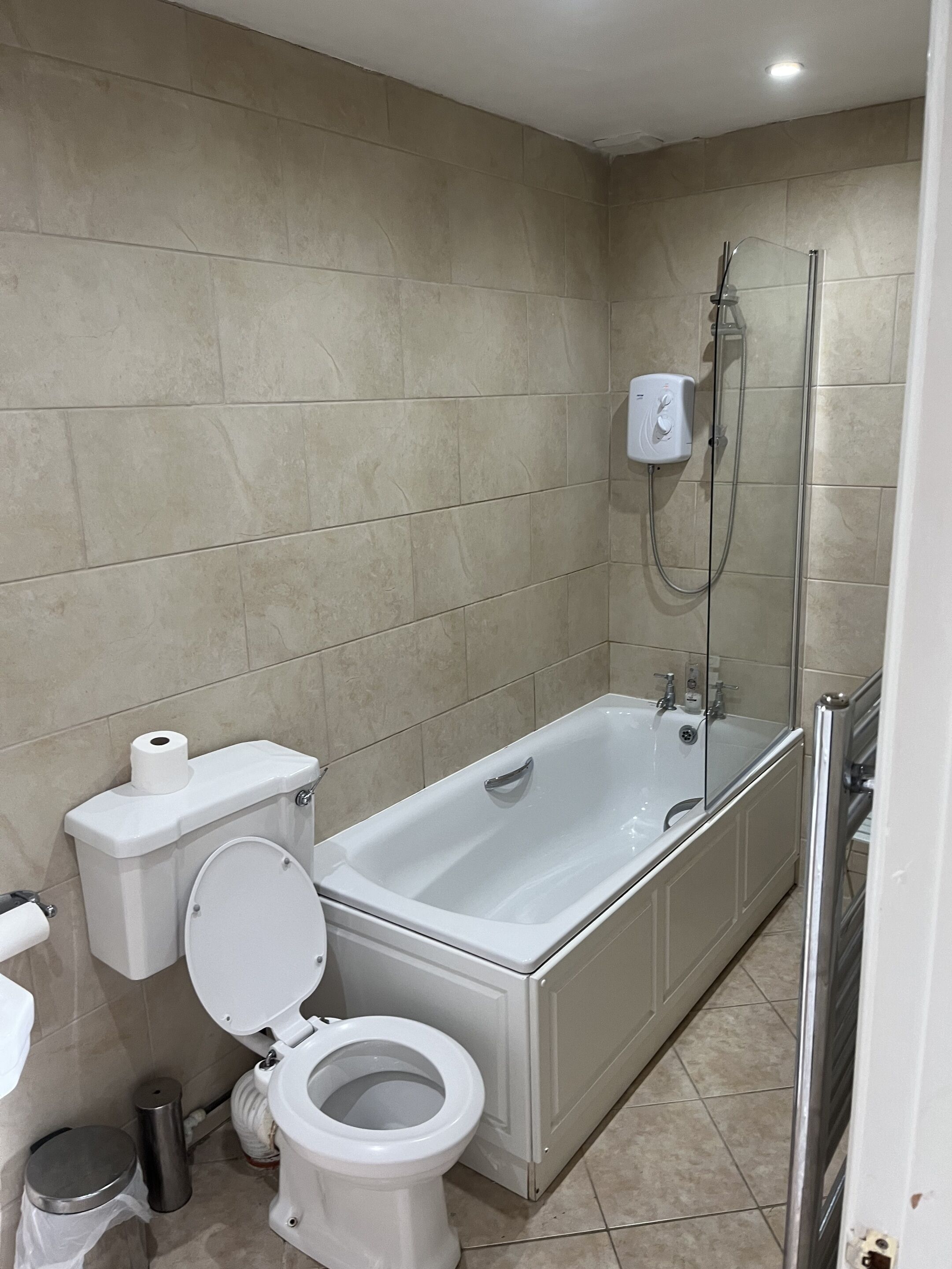 Moderni kylpyhuone, jossa on kylpyamme, wc ja suihku.