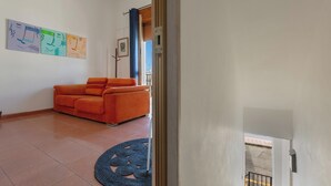A living room with a sofa, a blue rug, and wall art.