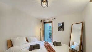 A bedroom with a bed, a large mirror, and a view of the outdoors. - Pilànous Residence - Junior Suite - Swiss Alps (Haute-Nendaz)