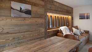 A wooden-paneled room with a wooden table and leather sofa. - Pilànous Residence - Junior Suite - Swiss Alps (Haute-Nendaz)
