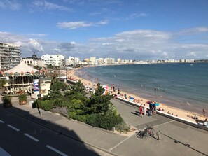Eine Küstenlandschaft mit Strand, Promenadenweg und Karussell.