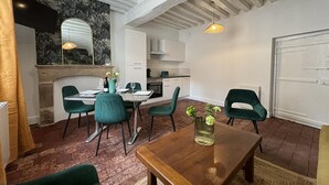 Ein Essbereich mit Holztisch, grünen Stühlen und Pendelleuchten.