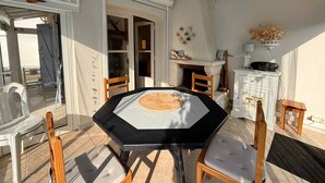 A dining area with a black table and wooden chairs, a white cabinet with a radio, and a fireplace. - Last Minute! 8-Person Holiday Home with WiFi Near Beach in La Tranche-sur-Mer (La Tranche-sur-Mer)