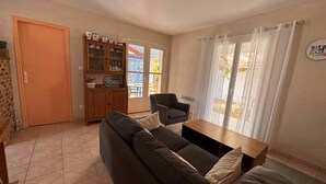 A living room with a sofa, a wooden cabinet, and a table. - Last Minute! 8-Person Holiday Home with WiFi Near Beach in La Tranche-sur-Mer (La Tranche-sur-Mer)