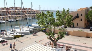 A marina with boats docked, a tree in the foreground, and buildings in the background. - 6-person apartment with pool in Gruissan (Gruissan)