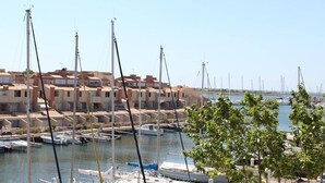 A marina with multiple sailboats docked, surrounded by residential buildings with terracotta roofs. - 6-person apartment with pool in Gruissan (Gruissan)