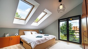 A bedroom with a skylight, a bed, a wardrobe, and a view of the outside. - Welcome to your dream retreat at our exquisite loft-style villa. (Budapest)