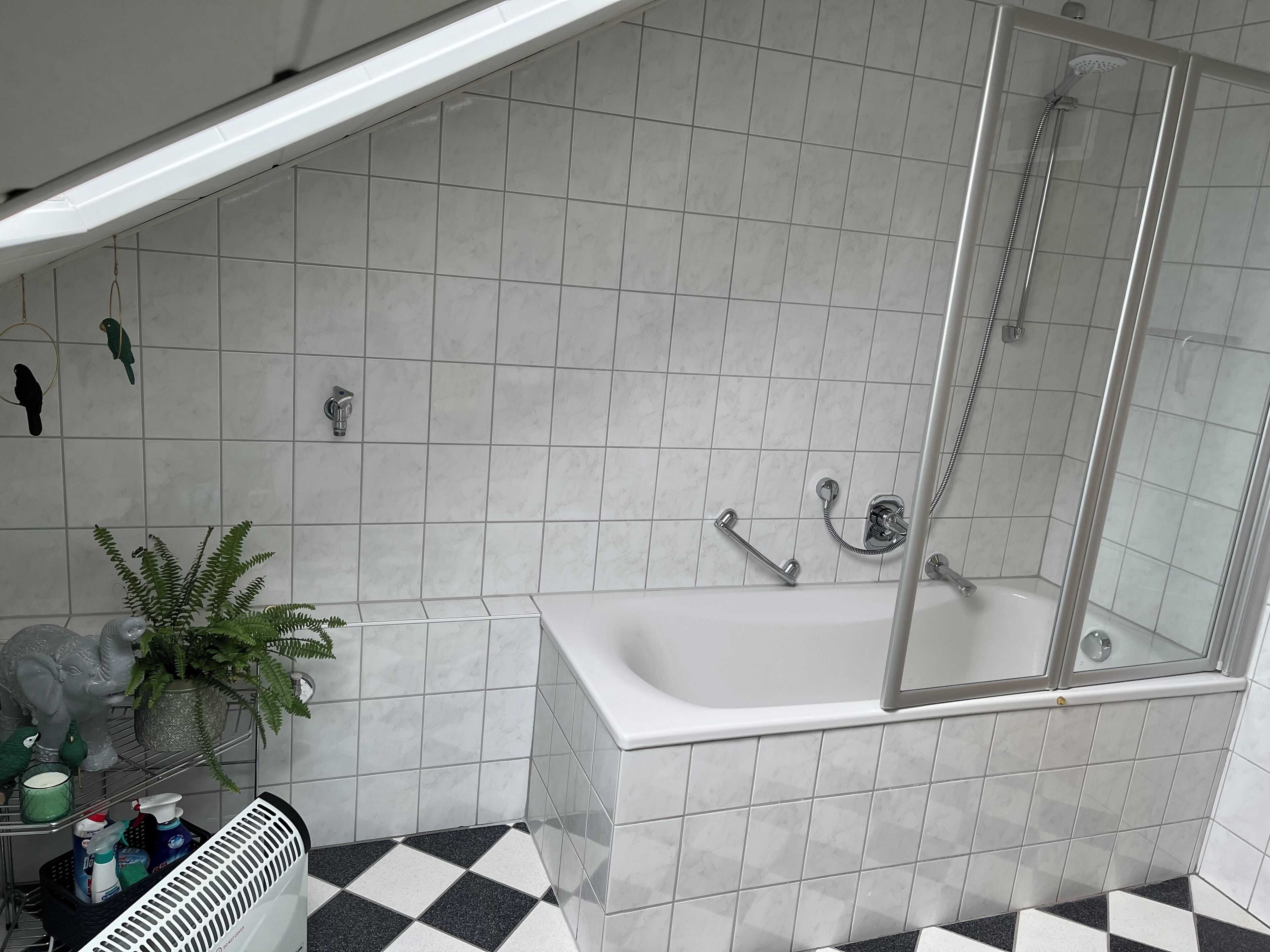 A bathroom with a bathtub, a shower, and a checkered floor.