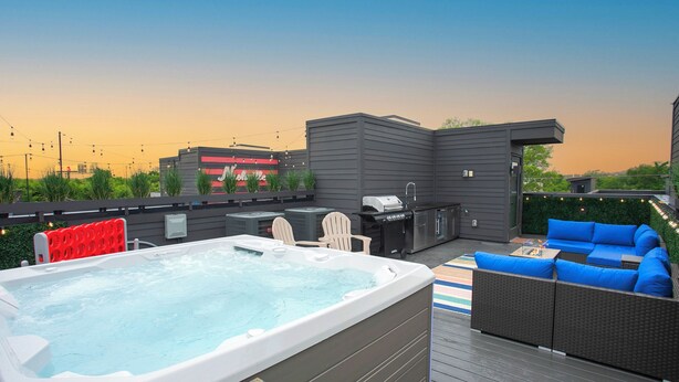 A hot tub, outdoor seating, and a grill on a deck. - Hot Tub & Rooftop Views - Twang Town Terrace (Nashville)