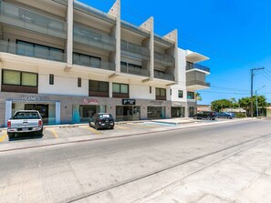 Ein mehrgeschossiges Gebäude mit Gewerbeflächen im Erdgeschoss, darunter eine Bank, eine Autowaschanlage und ein Restaurant.