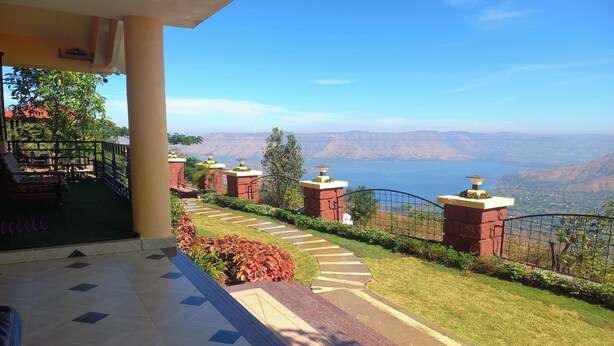 A hotel balcony with a view of a mountainous landscape. - Blossom Stay (Mahabaleshwar)