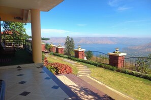 A hotel balcony with a view of a mountainous landscape.