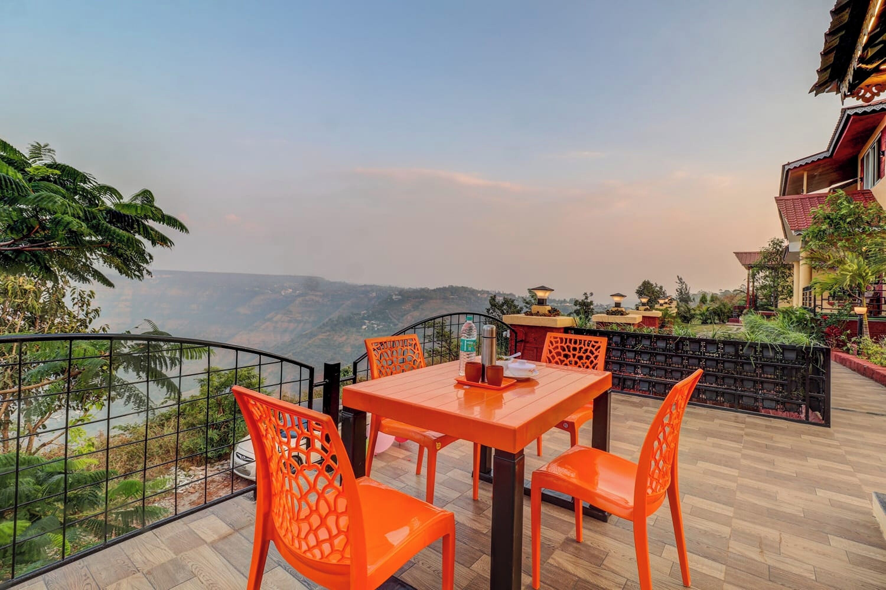 A terrace with a table and chairs, overlooking a scenic view.