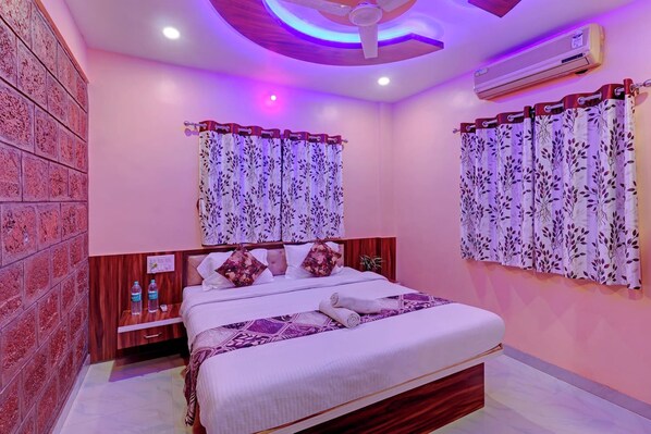 A bedroom with a bed, a nightstand, an air conditioner, and a wall with a brick pattern.