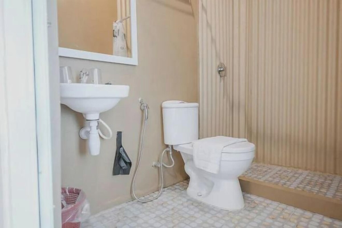 A bathroom with a toilet, sink, and shower.