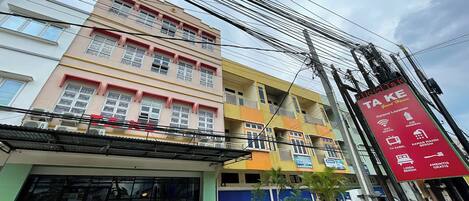 Un edificio de varios pisos con un cartel publicando los servicios de una casa de huéspedes.