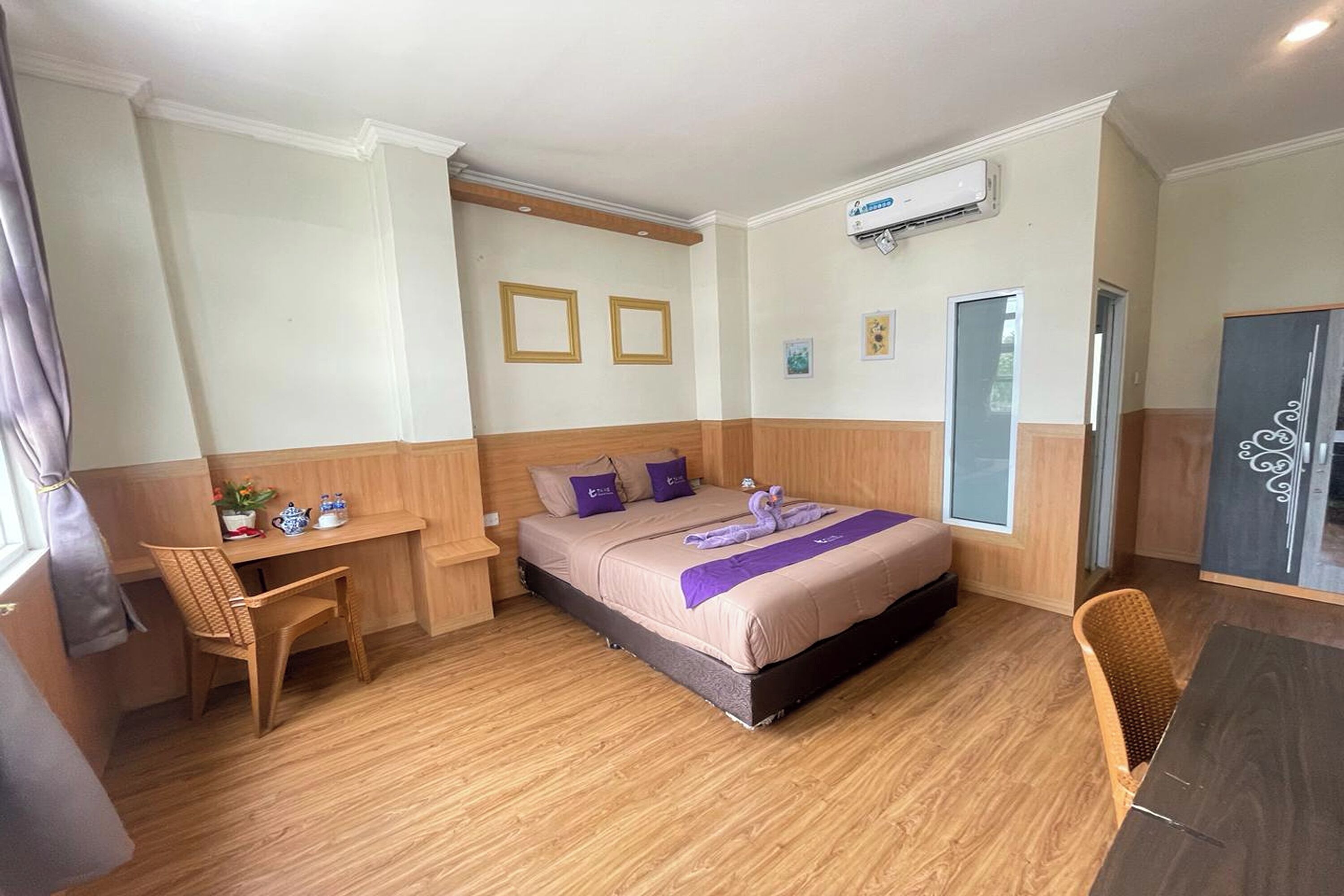 Una habitación de hotel con cama, escritorio, silla y armario.