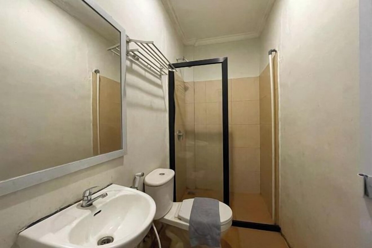 A bathroom with a sink, toilet, and glass-enclosed shower.
