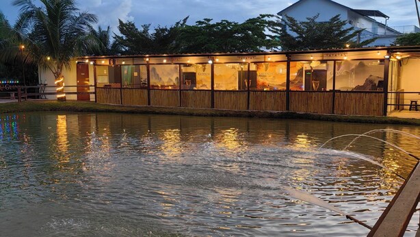 Un restaurante frente al agua, con vistas al mar y montañas al fondo.