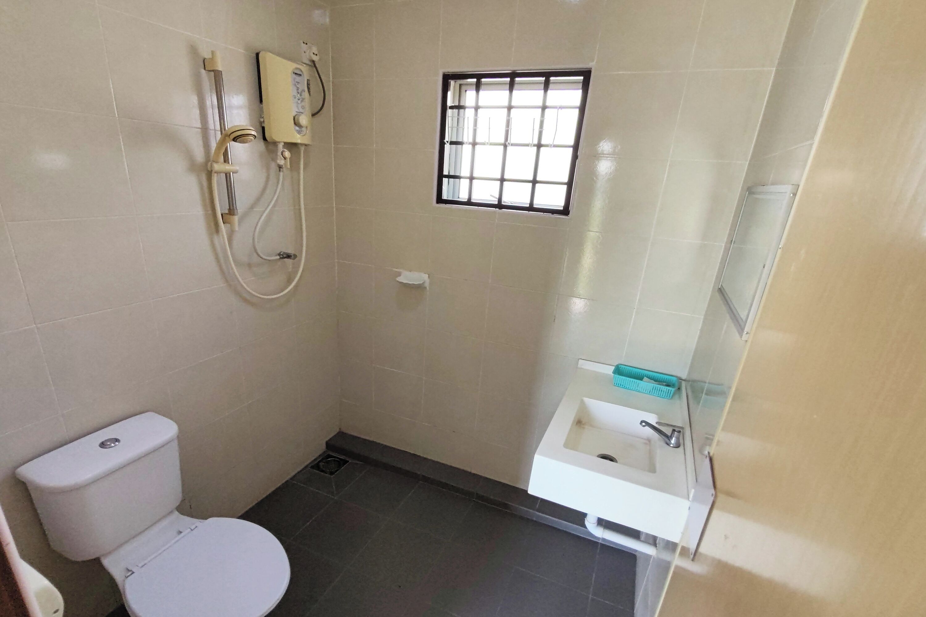 Un baño pequeño con inodoro, cabina de ducha y lavamanos.