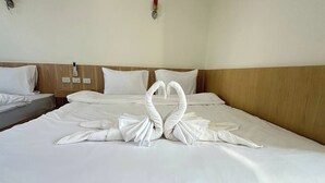 A hotel room with a large bed, two pillows, a bedside table with a lamp, and a wall-mounted outlet. - The White House P&N Hotel Chiang Rai (Wiang Chai)