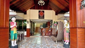 A traditional entrance with two statues, a tiled floor, and a wooden ceiling. - Sawadeelanna Hotel (Nan)
