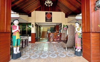 Una entrada tradicional con dos estatuas, suelo de baldosas y techo de madera.