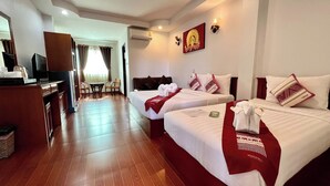 A hotel room with two beds, a desk with a television, and a dining area. - Sawadeelanna Hotel (Nan)