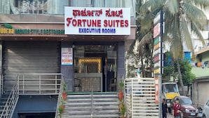 Um edifício com uma placa indicando 'Fortune Suites Executive Rooms'.