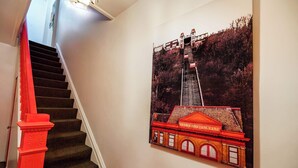 Una escalera con barandillas rojas y un cuadro colgado en la pared de un edificio con un cartel que dice "DUQUESNE SNE INCLINE".