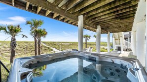 A hot tub under a wooden structure with palm trees and a view of the beach. - Lowe Tide, Fantastic Private Beach Front Home. 5 Stars! (Navarre)