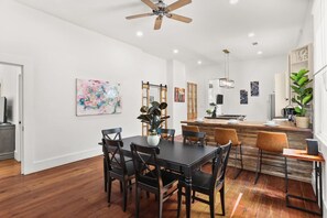 A modern kitchen with a central island, wooden flooring, and a ceiling fan. - Marigny Retreat | Steps to Trolley, French Quarter (New Orleans)