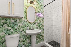 A bathroom with a white sink, a toilet, and a shower area. - Marigny Retreat | Steps to Trolley, French Quarter (New Orleans)