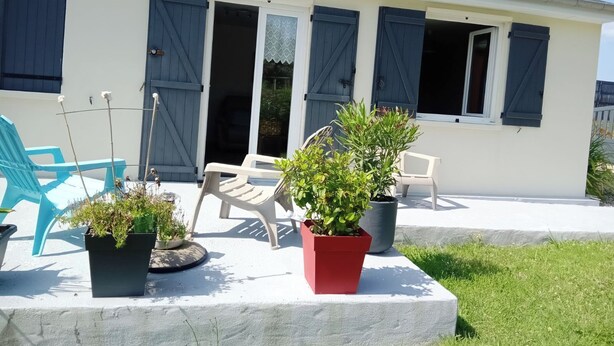 A house with a covered patio, two blue shutters, and a satellite dish. - Maison en Bordure de mer (Sotteville-sur-Mer)