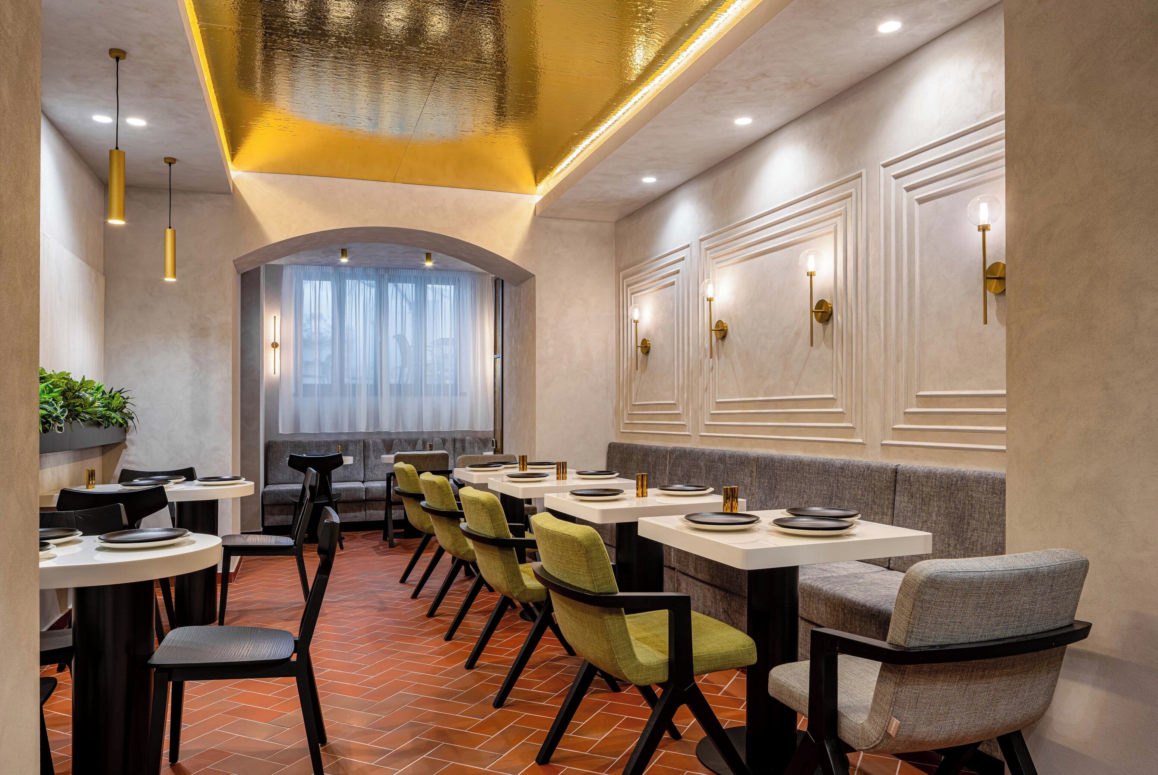 A restaurant with a long table, chairs, and a bar area.