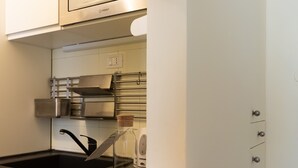 A modern kitchen with stainless steel appliances, a black sink, and a wooden countertop. - Italianway Easy - Cipro 5 (Milan)